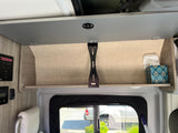 RV rental overhead cabinet showing tissue box, Winnebago control panel, & open storage space above a window.