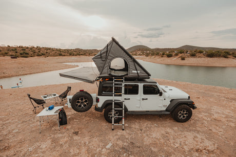 This RV rental features a Jeep with a rooftop tent, camping gear, and a lake view. Perfect for an outdoor adventure!