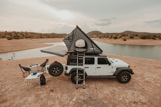 This RV rental features a Jeep with a rooftop tent, camping gear, and a lake view. Perfect for an outdoor adventure!