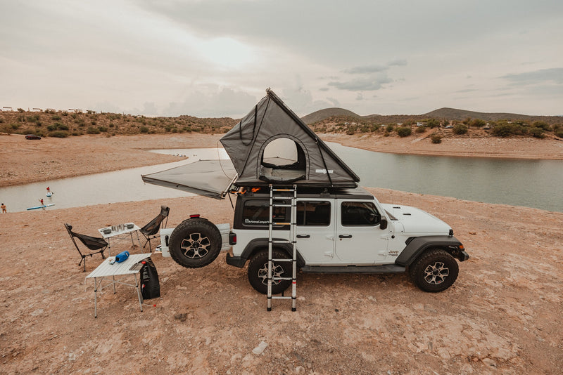 This RV rental features a Jeep with a rooftop tent, camping gear, and a lake view. Perfect for an outdoor adventure! — photo 1
