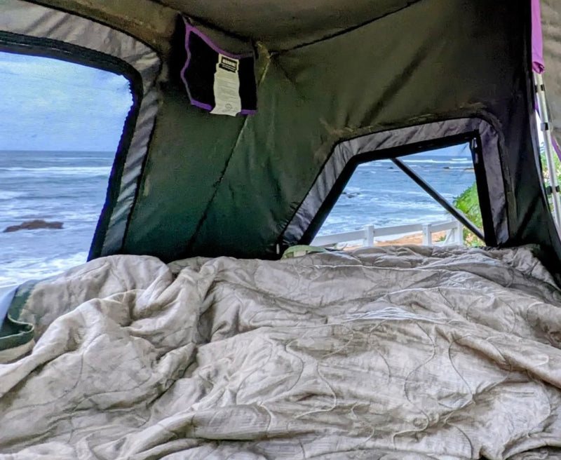 Inside a comfy RV rental rooftop tent, overlooking waves & a beach. Perfect oceanfront glamping spot awaits! — photo 11