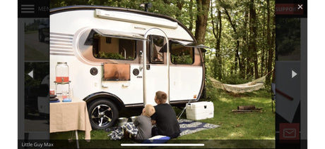 Family enjoying an RV rental camping trip! A Little Guy Max camper with outdoor TV, hammock in the serene woods.