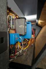 An RV rental's power hub: Victron DC/DC & MPPT chargers, inverter, and fused wiring for robust electrical setup.