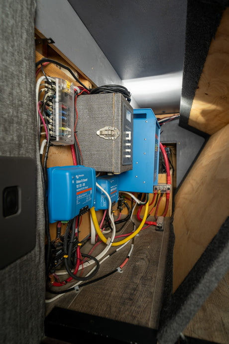 An RV rental's power hub: Victron DC/DC & MPPT chargers, inverter, and fused wiring for robust electrical setup.