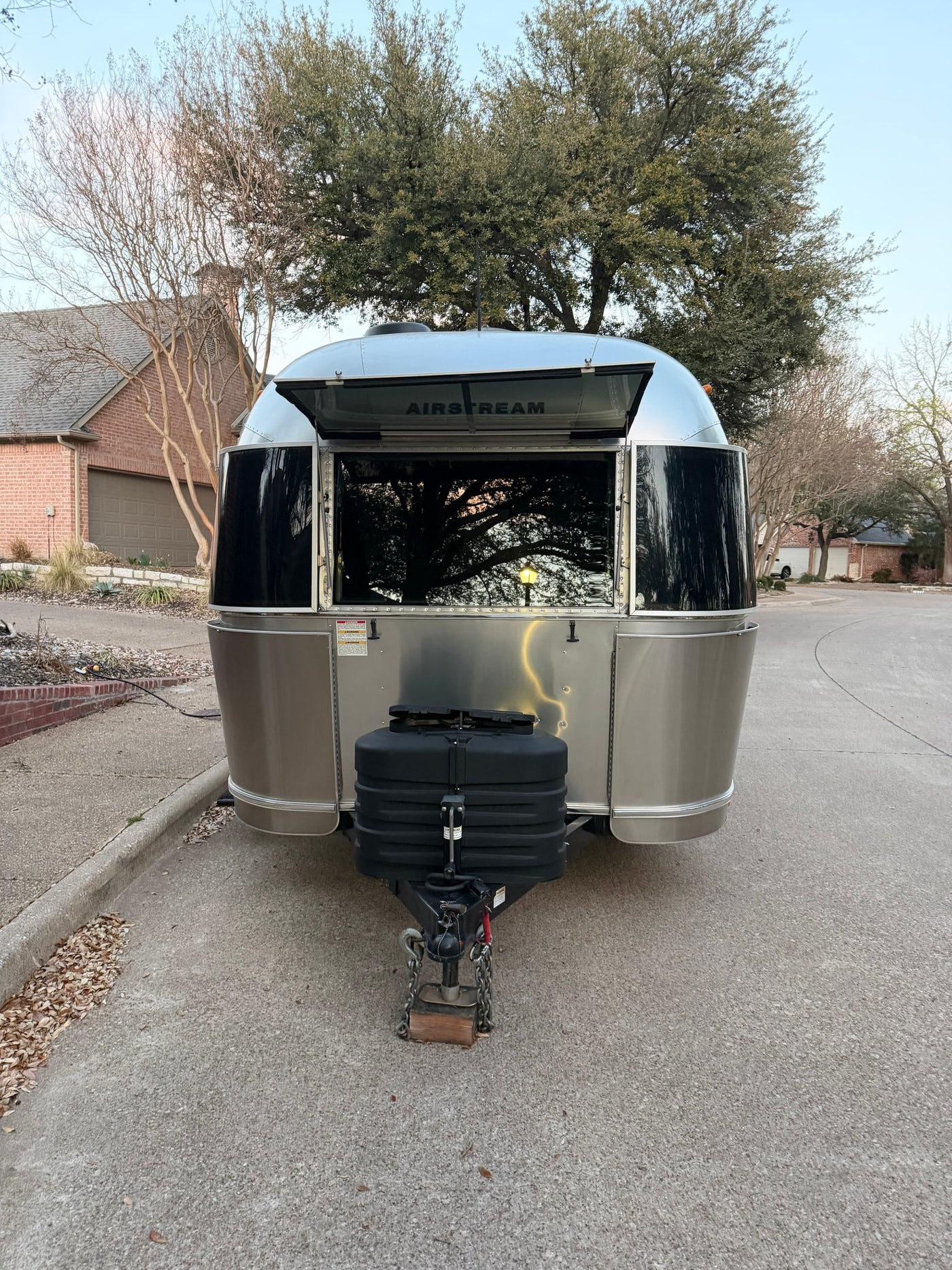 This silver Airstream travel trailer with an open hatch, revealing its logo, is parked and ready for your RV rental adventure. — photo 2