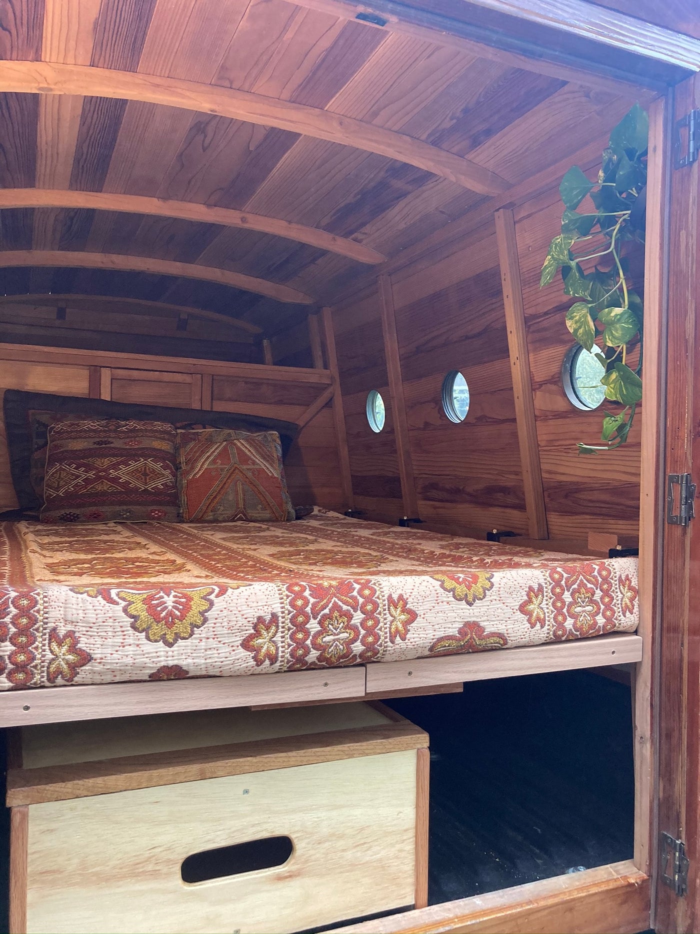  and an open door to a panoramic forest view under a blue sky.|Rustic RV rental interior: wood-paneled walls & ceiling — photo 4