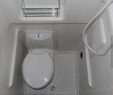 Compact white RV rental bathroom with a toilet, shower hose, and chrome shelf, ready for your trip.