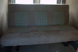 RV rental: Beige upholstered bench seat with three blue plaid sections, likely in a camper van interior.