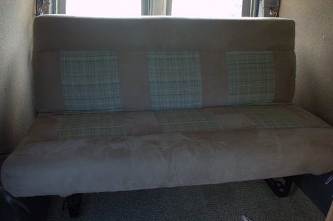RV rental: Beige upholstered bench seat with three blue plaid sections, likely in a camper van interior. — photo 8