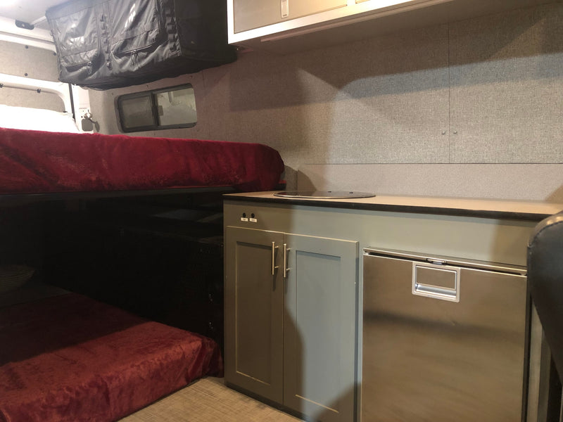 Inside an RV rental: features include bunk beds, a compact kitchenette with a fridge, and overhead storage. — photo 6