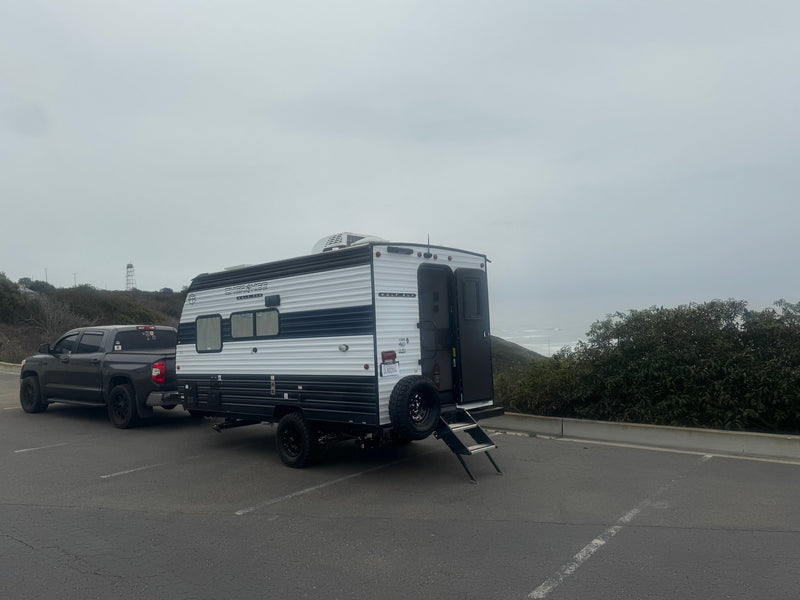  ready for your trip. Features shelves & door bins.|Compact RV rental kitchen features a Greystone stove — photo 7