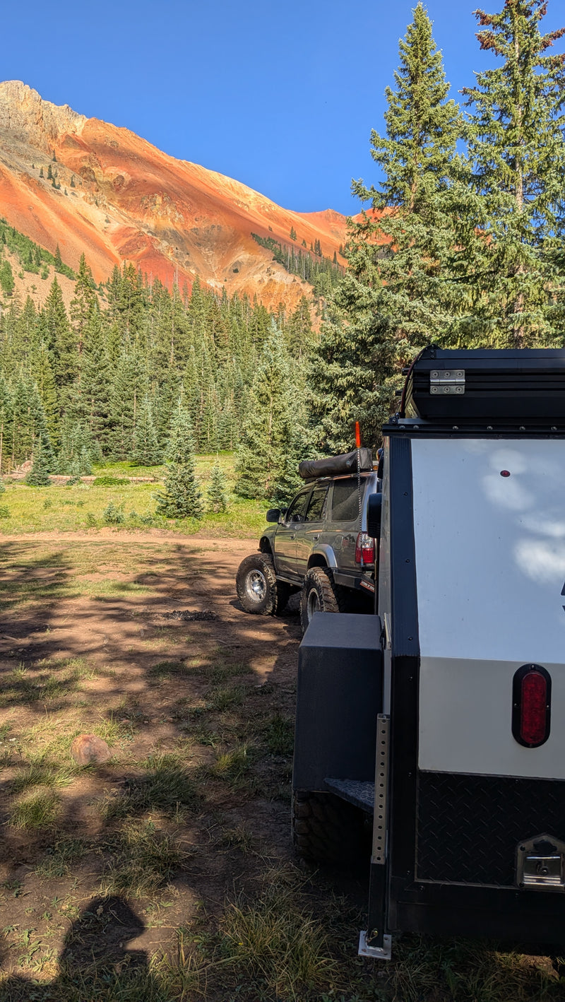 Overland rv rental with 4x4 SUV & trailer, camping by vibrant red mountains & dense pine forests under a blue sky. — photo 20