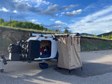 Compact RV rental camper with bikes & portable outdoor shower. Perfect for a roadside camping adventure.