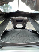Interior of a comfortable rooftop tent, perfect for an RV rental adventure. Features quilted mattress, mesh windows & storage.