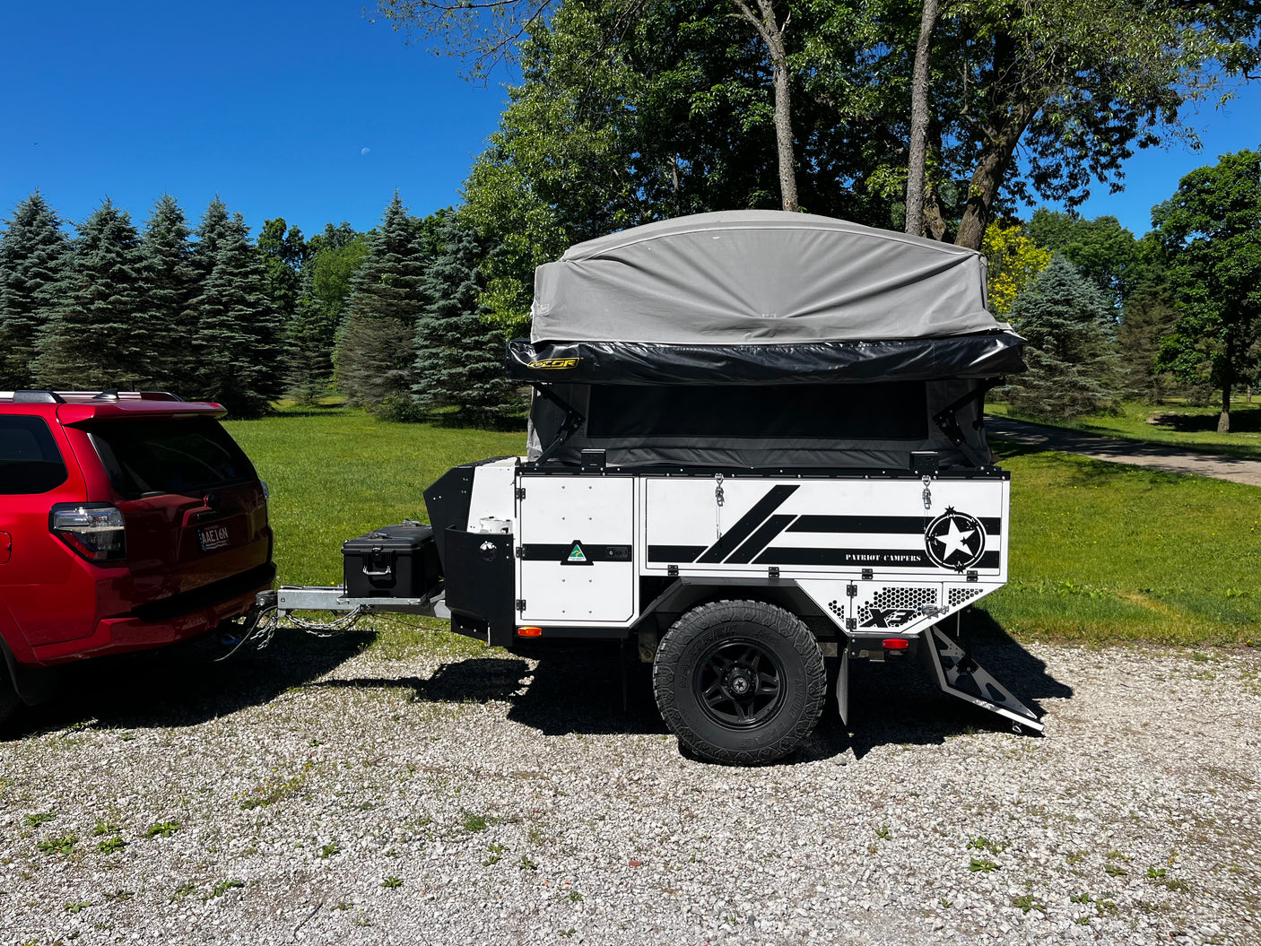 Patriot X3 trailer hooked up and ready to tow, tent up, three-quarter rear view