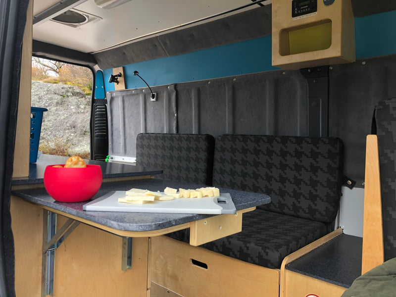  parked amidst urban graffiti and train tracks.|Spacious and functional camper van interior with bed — photo 4