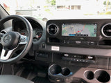 View of a modern Mercedes RV rental interior dashboard, featuring a navigation screen, steering wheel, and climate controls.