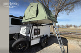 Explore with our TigerMoth rv rental! This compact trailer features a green rooftop tent & ladder for outdoor camping.