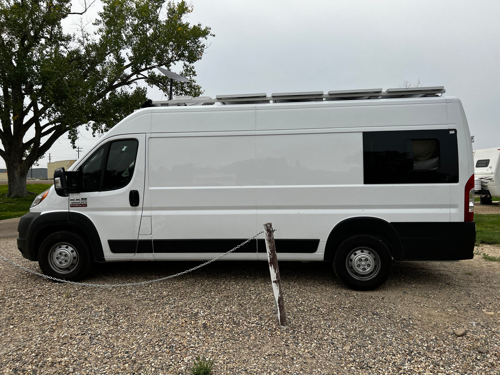 White Ram ProMaster camper van with solar panels & Starlink, ideal for RV rental adventures.