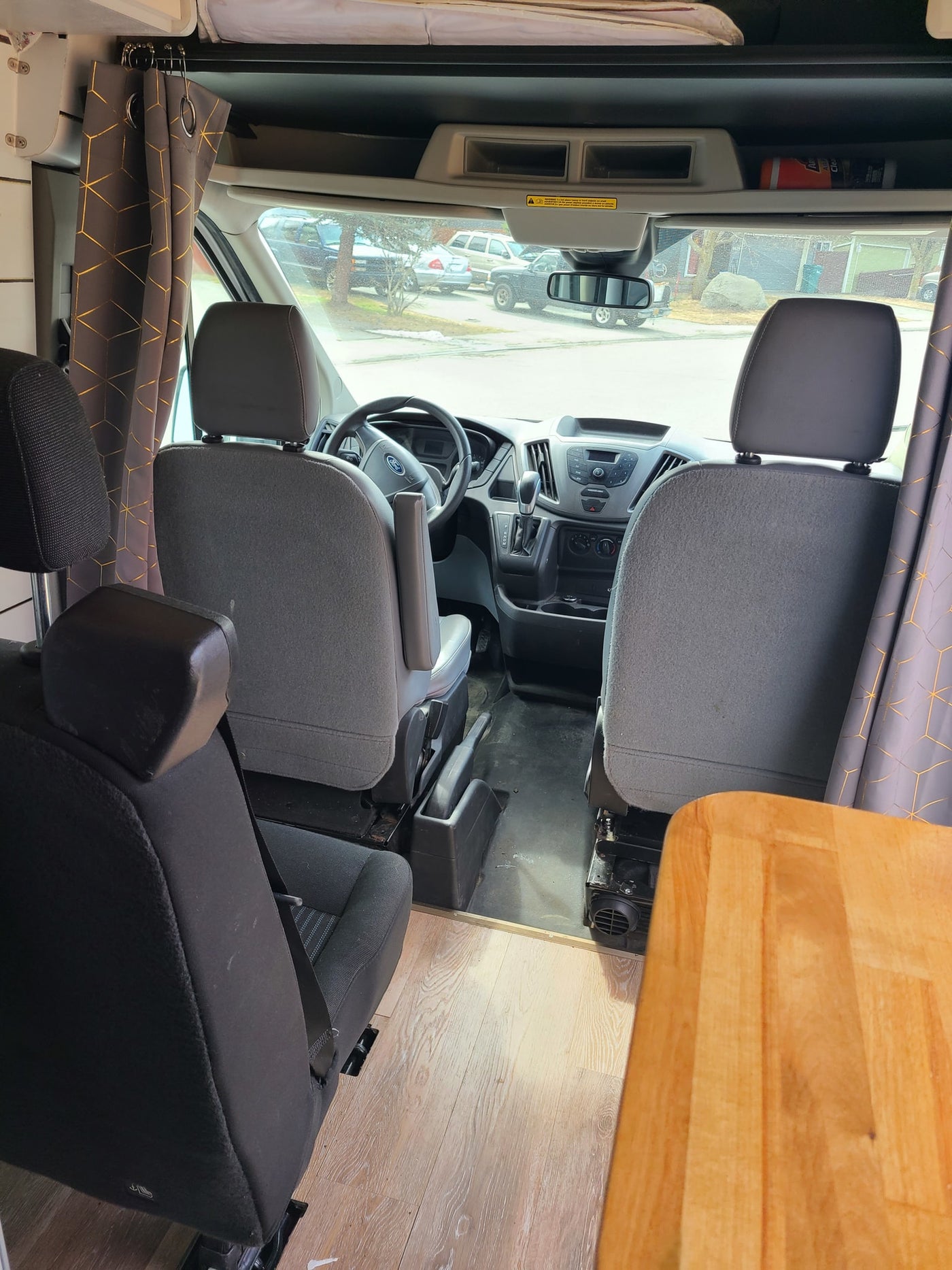 View from back of rv rental van showing front cabin, driver/passenger seats, rear seats, dashboard, and curtains. — photo 19