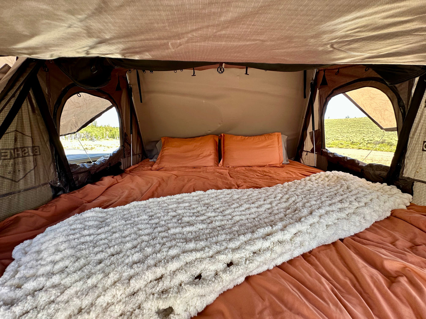 Cozy rooftop tent bed inside an RV rental, ready for adventure. Enjoy comfy camping with stunning views!
