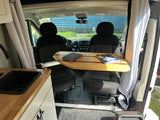  and overhead storage cabinets for comfortable travel.|RV rental interior with swivel seats and a unique wooden table