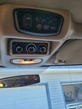 RV rental overhead console: Light and climate controls visible, with an illuminated dome light below.