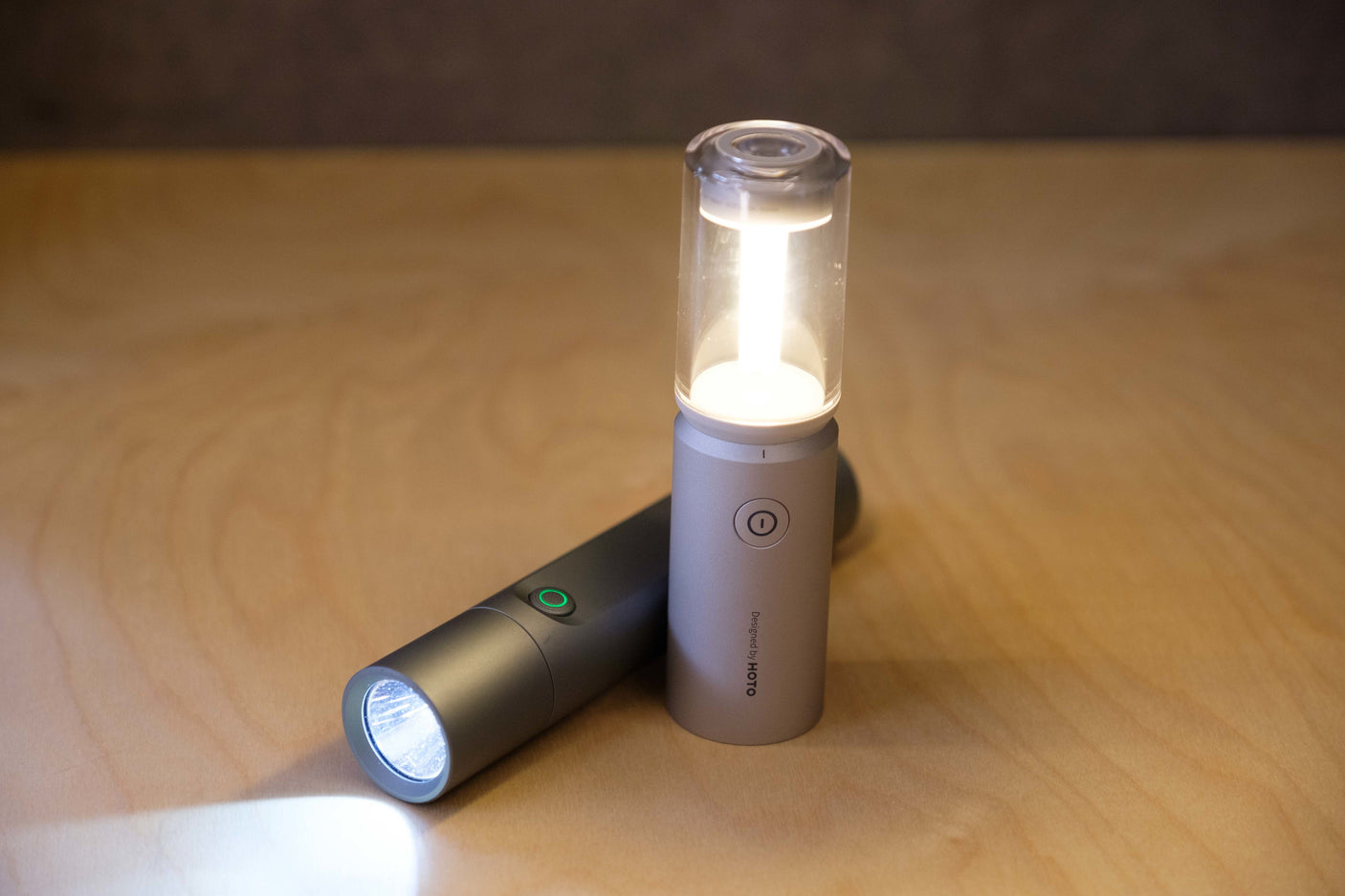 Two lit portable lights, a flashlight and lantern, on wood. Essential gear for your rv rental trips and outdoor adventures.