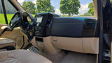 Luxury RV rental interior featuring a modern dashboard, steering wheel, and plush tan leather seating for comfortable travel.