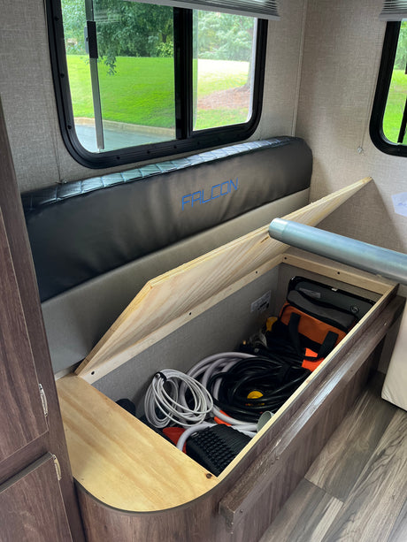 RV rental interior: Dinette bench lifts to reveal spacious under-seat storage for hoses & RV gear.