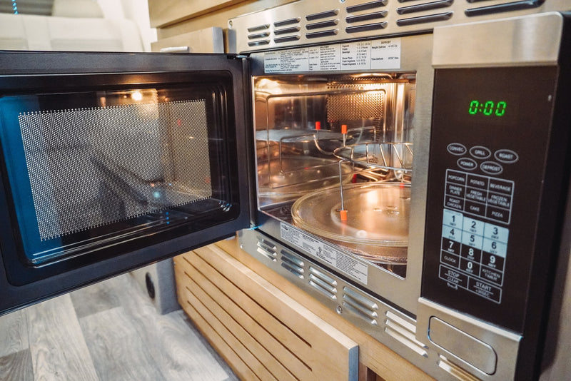 Open built-in microwave in an RV rental, showing interior glass turntable & detailed control panel with 0:00 display. — photo 5