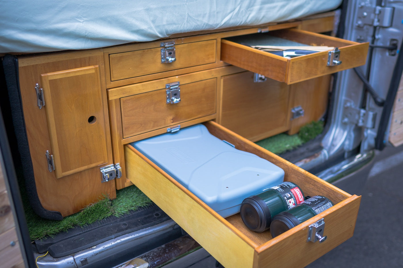  creating a charming camper feel.|Step into this inviting RV rental: a custom wood interior with a bed — photo 3