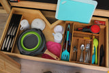 Organized kitchen essentials in an RV rental drawer, featuring knives, cookware, and utensils for compact living.