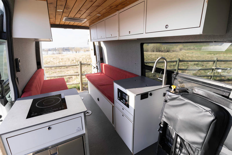 Spacious RV rental interior featuring a kitchenette with cooktop and sink — photo 1