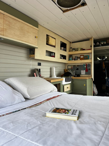  with a handy workspace and storage for an ideal getaway.|RV rental interior: bed