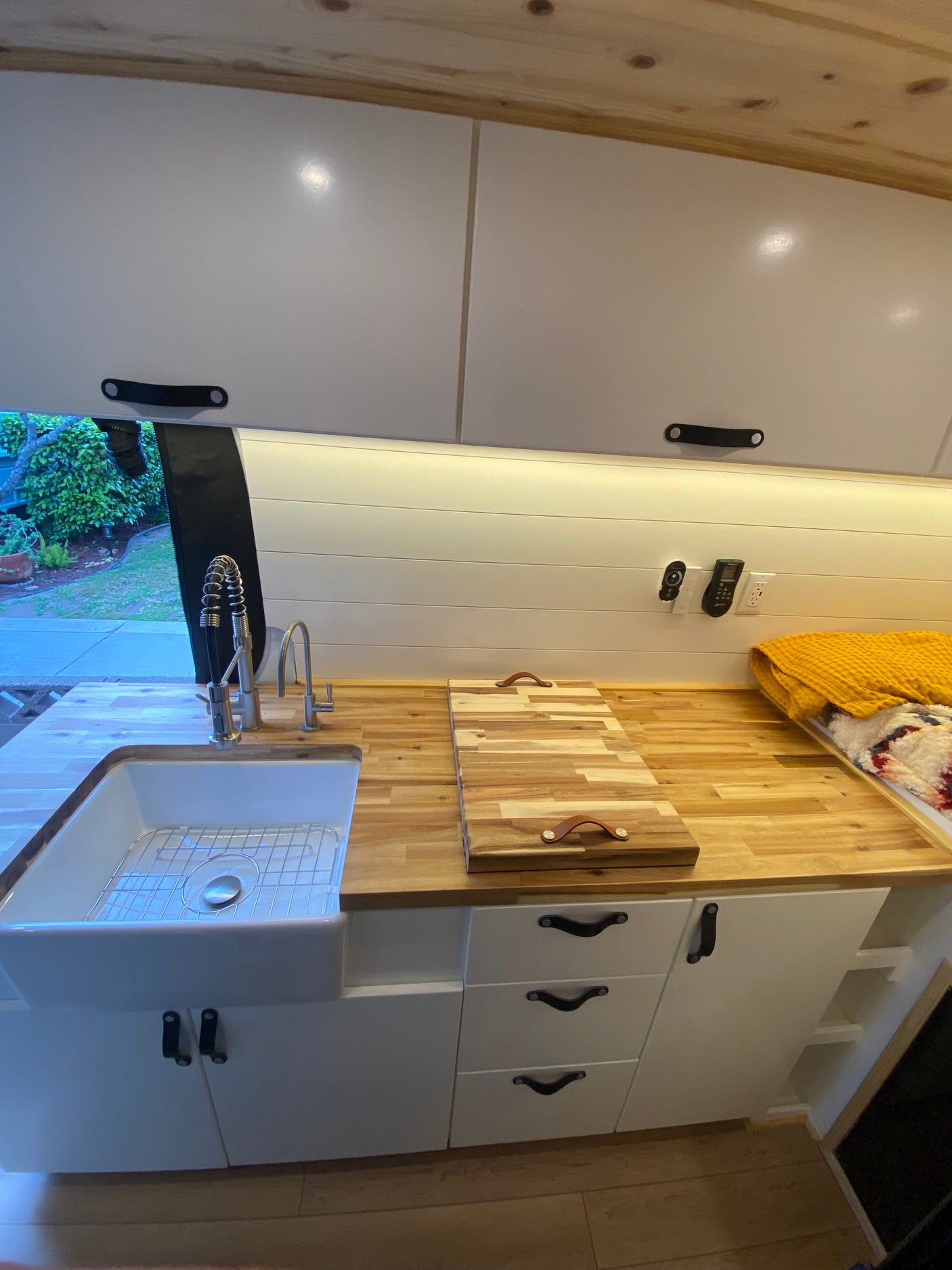 RV rental interior: A bright, modern kitchen features a large white sink, butcher block counters, and ample white cabinetry.