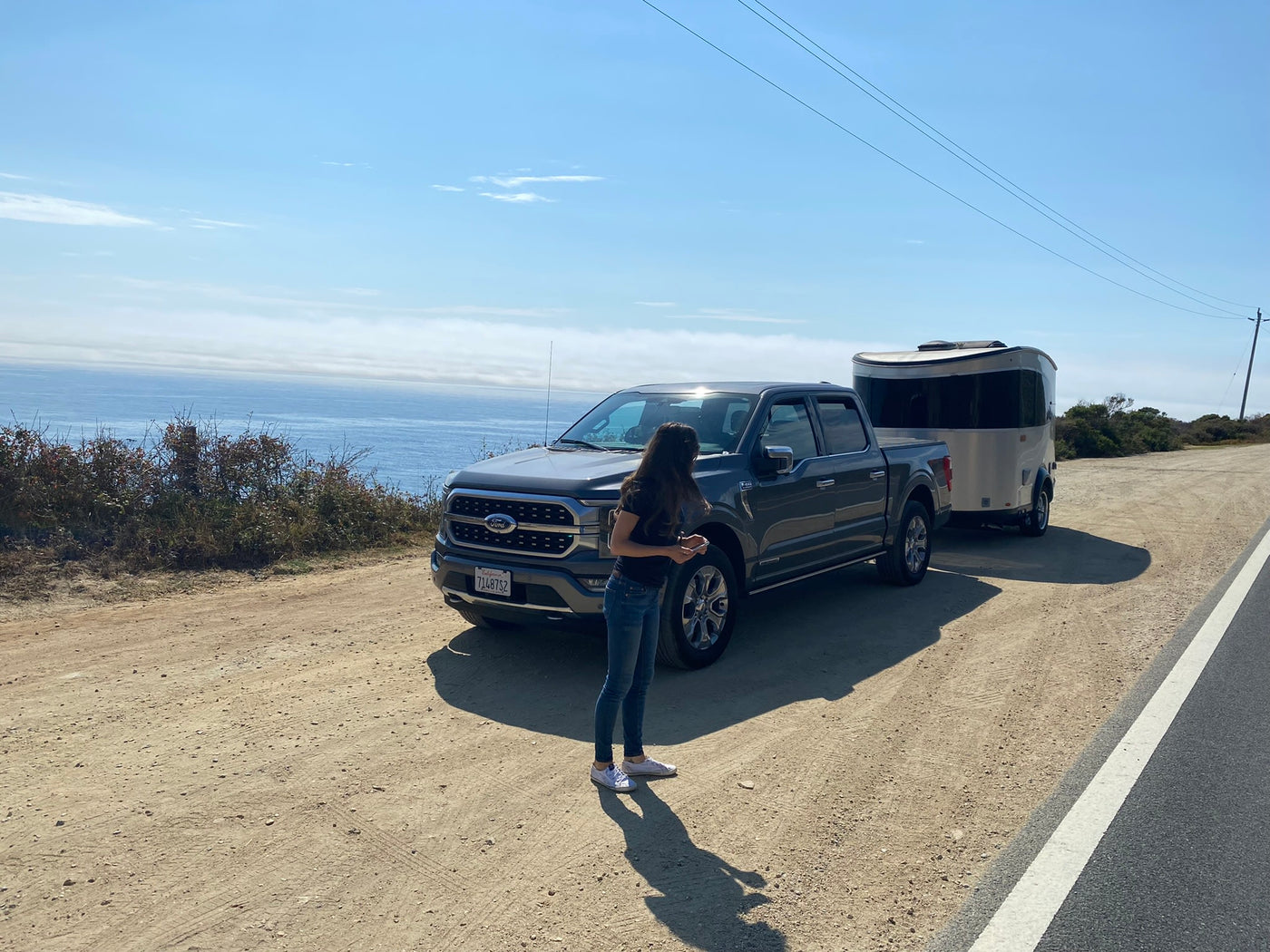 Scenic stop with our RV rental: a Ford truck towing a silver travel trailer overlooking the ocean. — photo 2