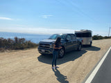 Scenic stop with our RV rental: a Ford truck towing a silver travel trailer overlooking the ocean.