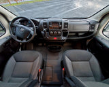 Ram van RV rental interior: overhead view of front cabin with steering wheel, infotainment dashboard, and seats.