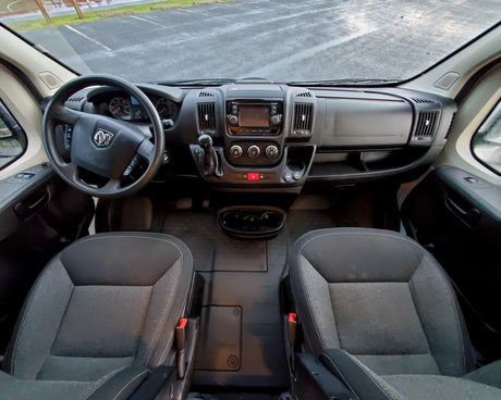 Ram van RV rental interior: overhead view of front cabin with steering wheel, infotainment dashboard, and seats.