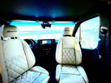 Regency RV rental: luxurious white quilted seats facing a beautiful ocean and beach view.