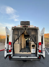 Experience freedom! This RV rental van's open rear reveals a spacious, customized interior for your next road trip adventure.