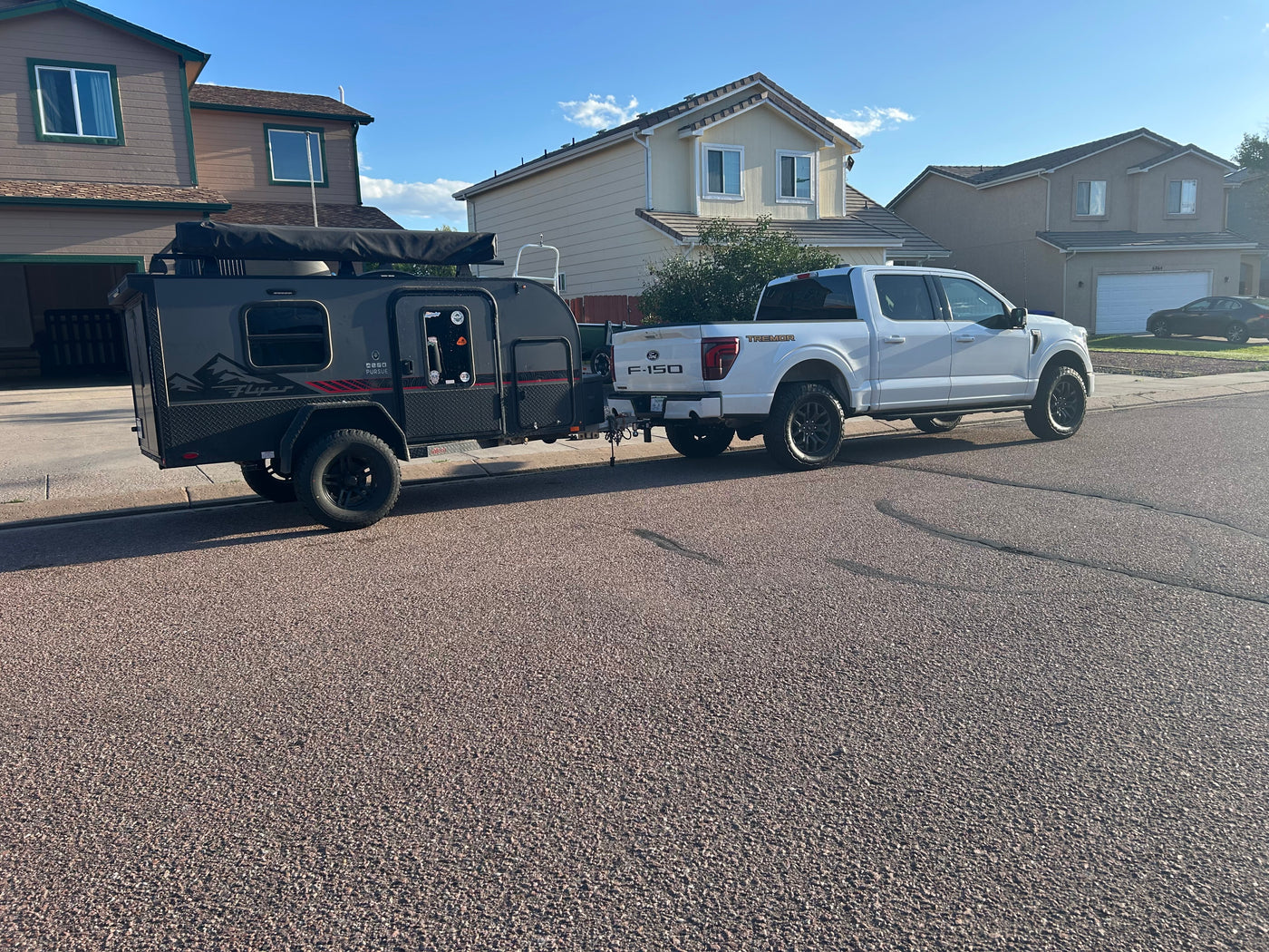 White Ford F-150 Tremor towing a Flyer Pursue RV rental trailer, ready for adventure in a suburban setting. — photo 4
