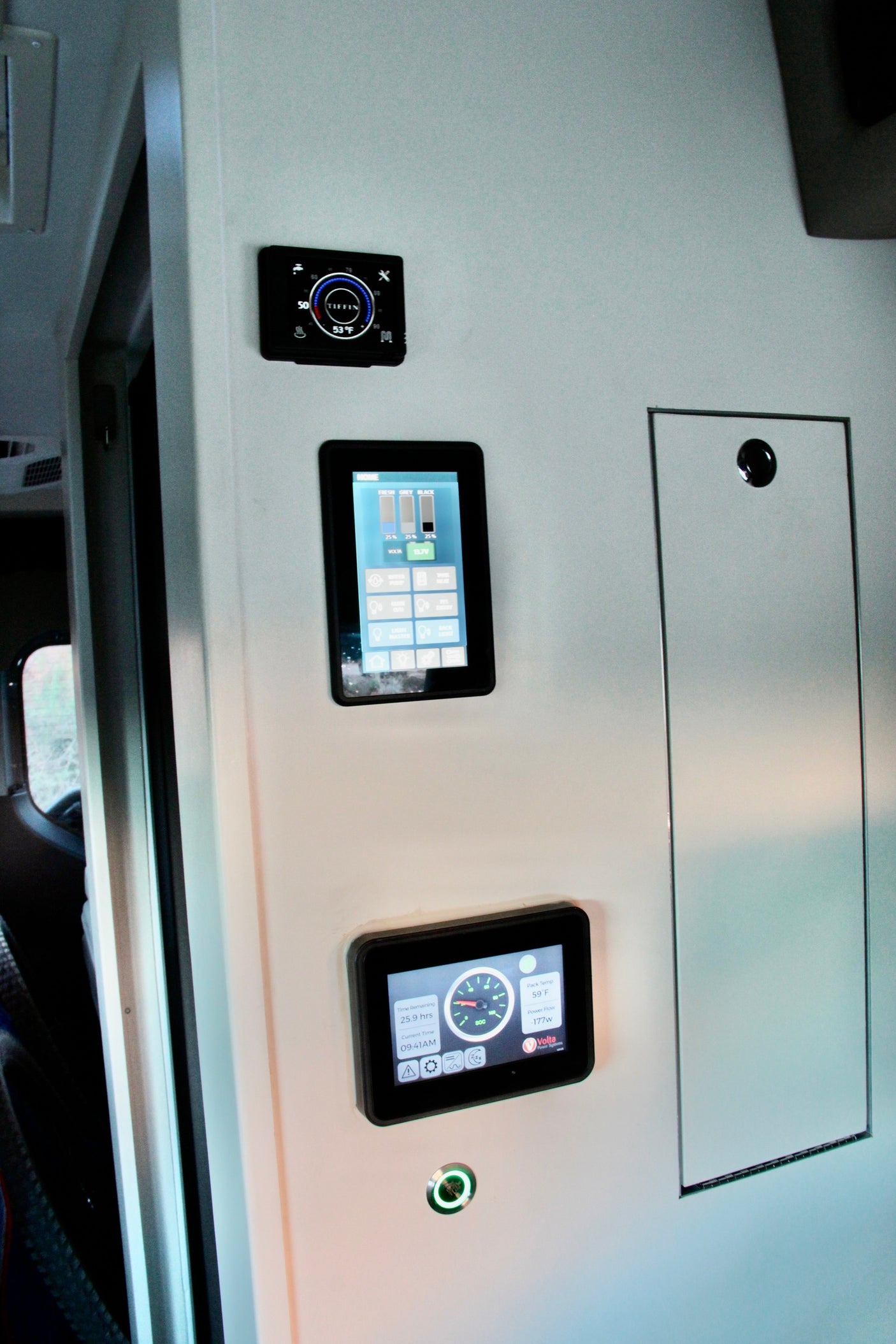 RV rental interior wall: Digital displays show Tiffin thermostat, tank levels, and Volta power system for easy monitoring.
