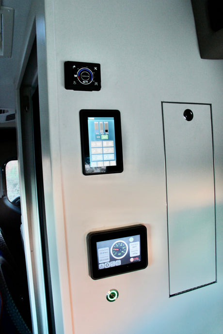 RV rental interior wall: Digital displays show Tiffin thermostat, tank levels, and Volta power system for easy monitoring.