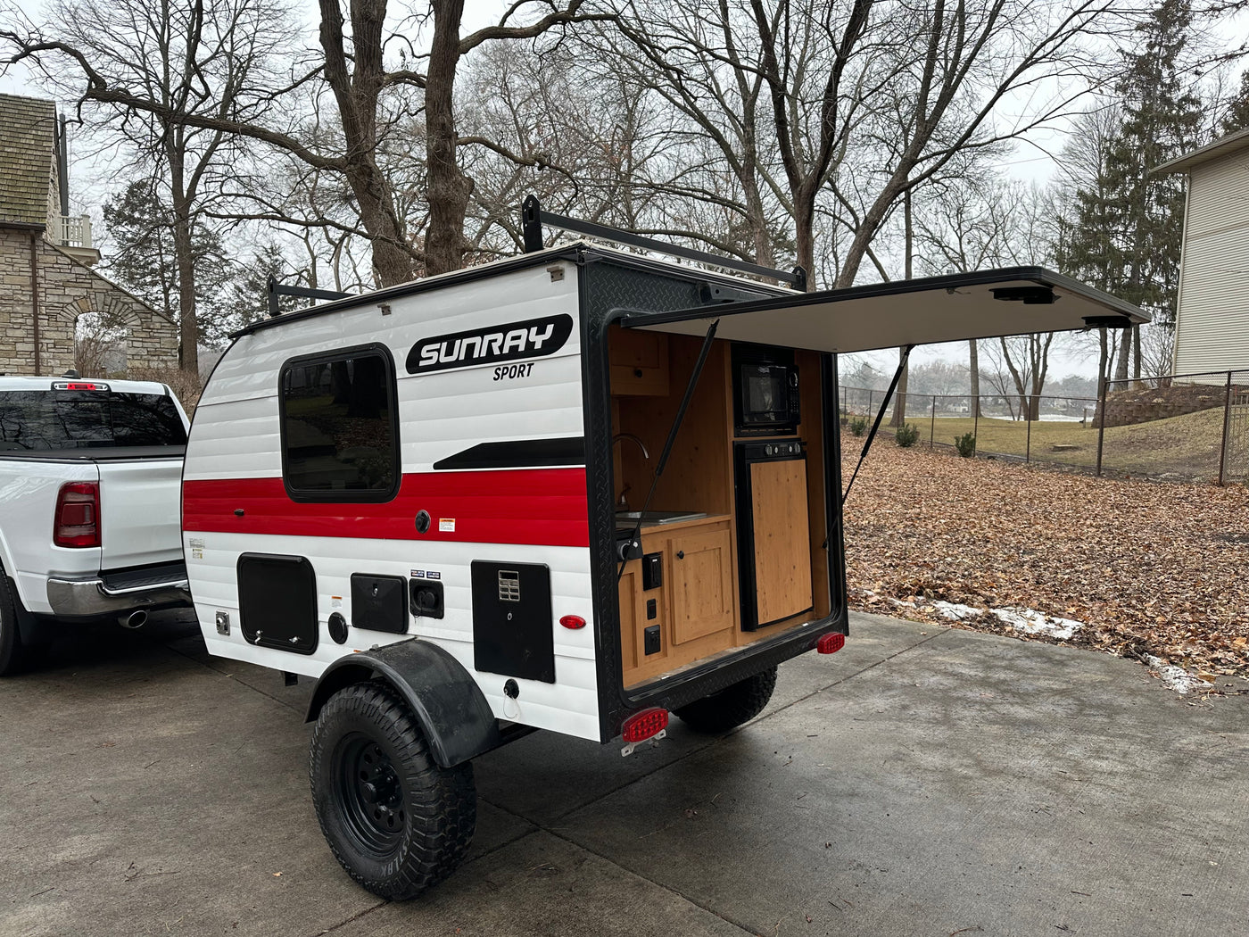 White Sunray Sport teardrop camper RV rental with open rear kitchen, perfect for outdoor travel.