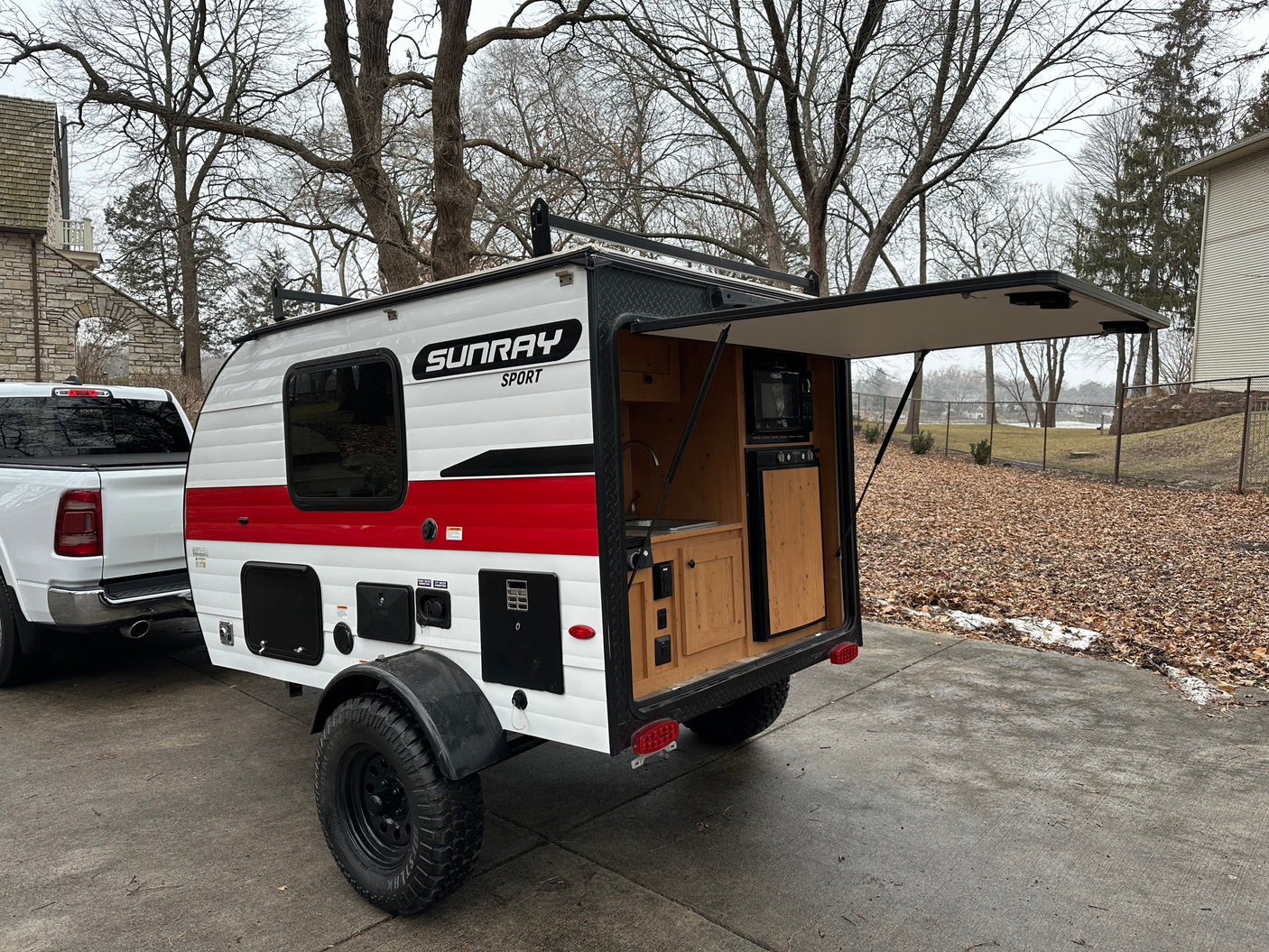 White Sunray Sport teardrop camper RV rental with open rear kitchen, perfect for outdoor travel.