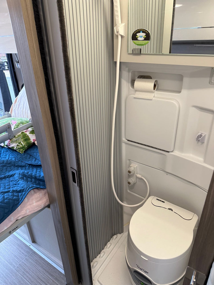  and camping gear seen.|Inside a spacious RV rental: a plush bed with a flamingo pillow