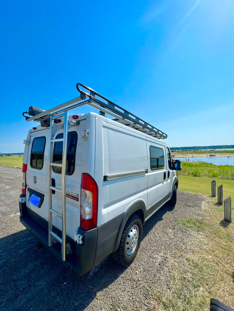 White RV rental camper van with a roof rack and ladder, parked lakeside on a sunny day, ready for outdoor adventures. — photo 13