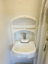 Compact bathroom sink and faucet, a key amenity in this RV rental.